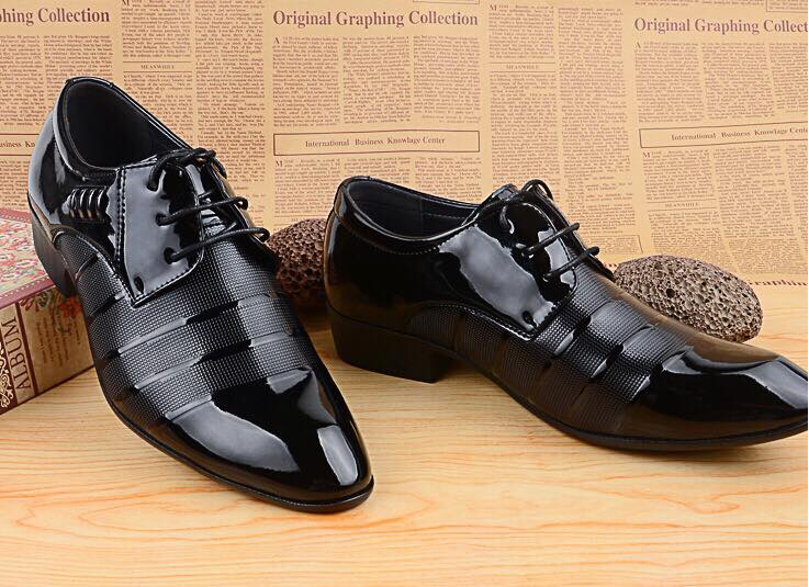Pair of black dress shoes on a wooden surface with a newspaper background