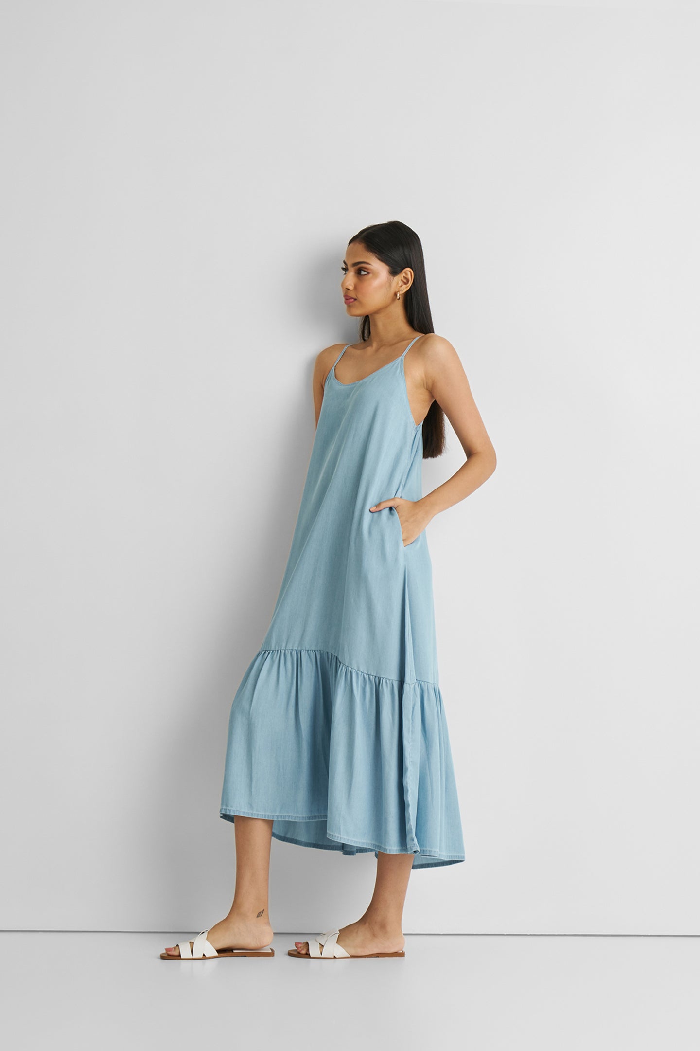 Woman wearing a light blue dress against a white background
