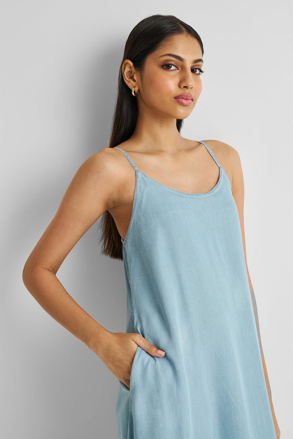 Woman wearing a light blue dress against a plain background