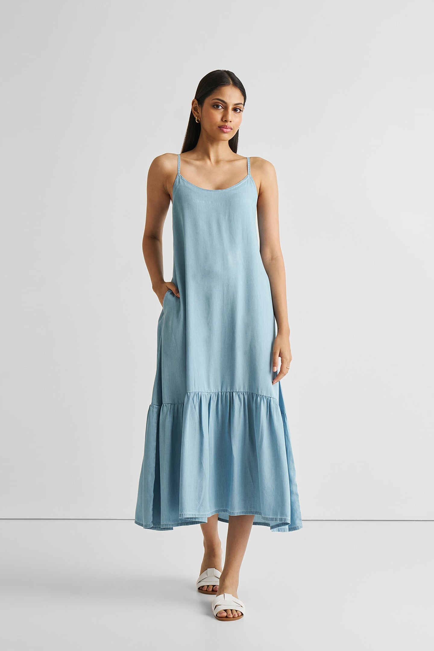 Woman wearing a light blue dress against a white background