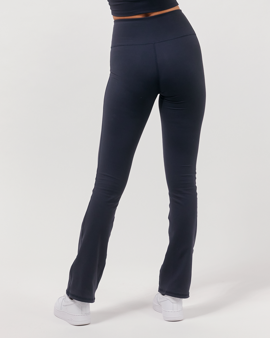Person wearing navy blue leggings on a white background