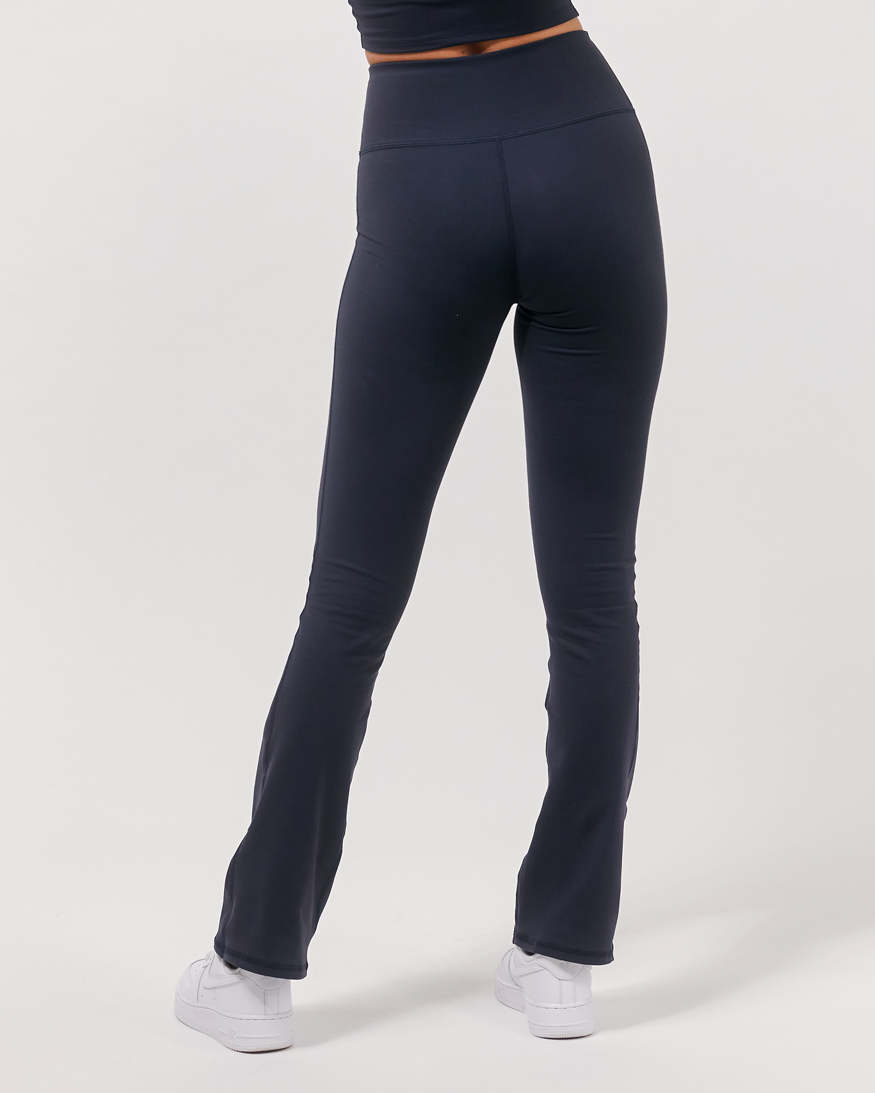 Person wearing navy blue leggings on a white background