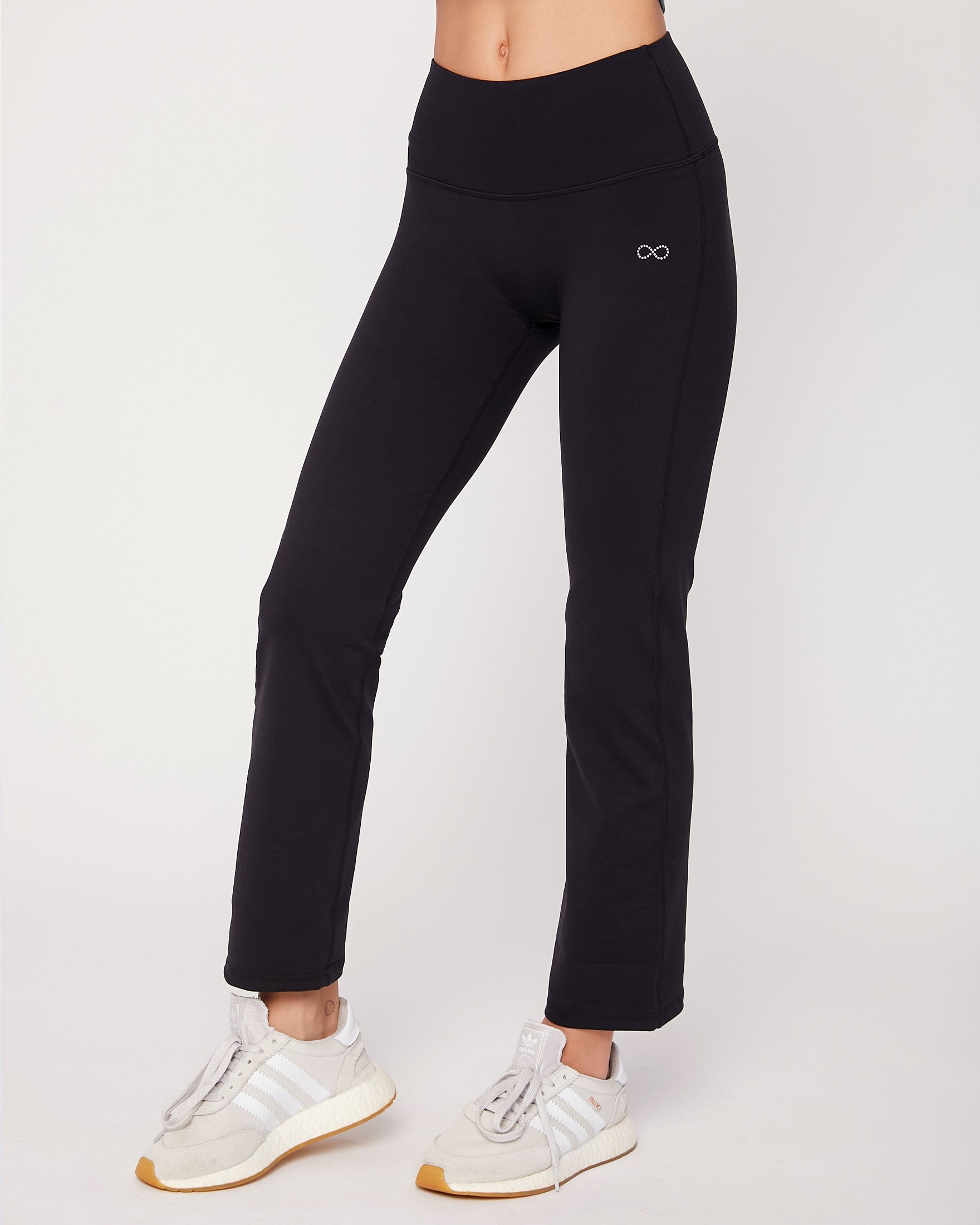 Person wearing black leggings with a brand logo on a white background