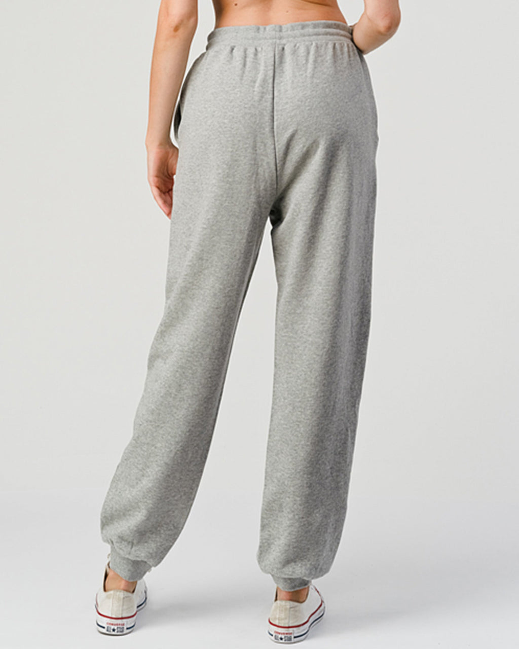 Gray sweatpants worn by a person on a white background