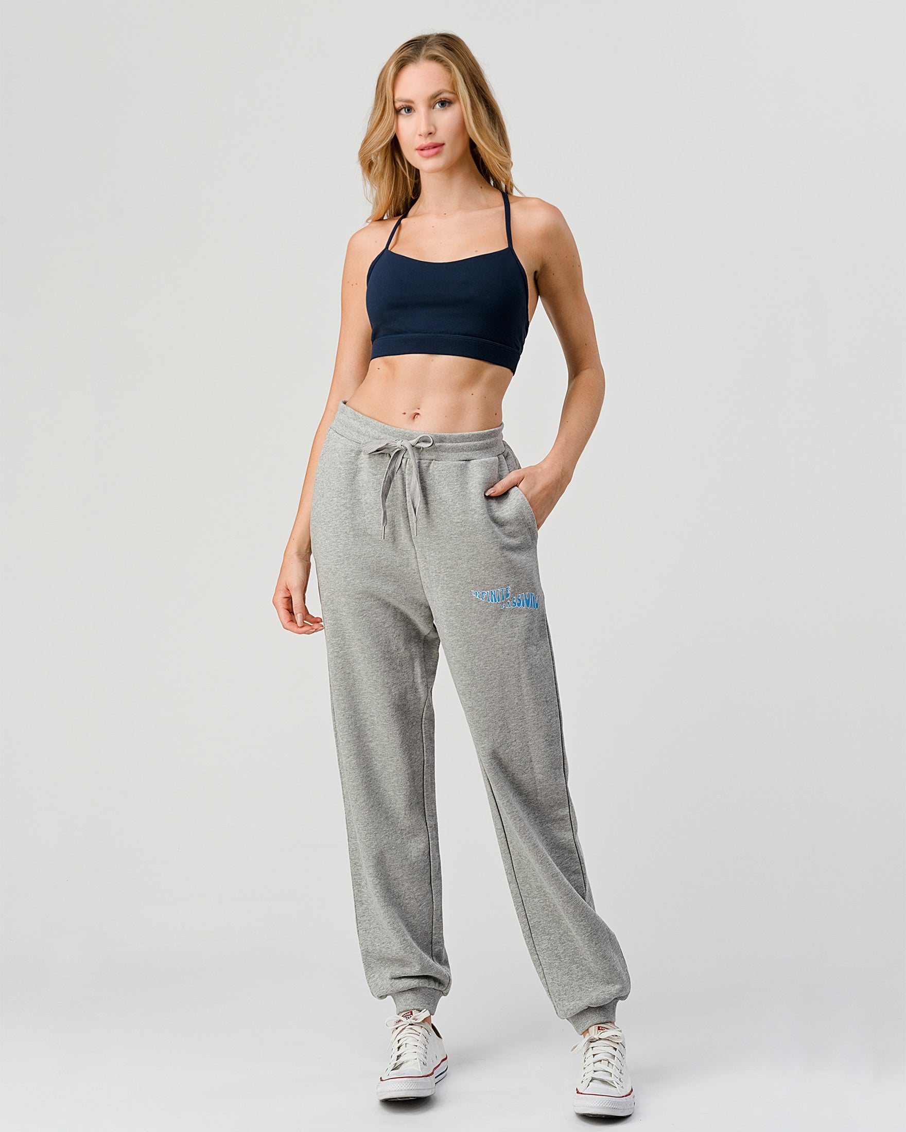 Woman wearing gray sweatpants with a logo on a white background