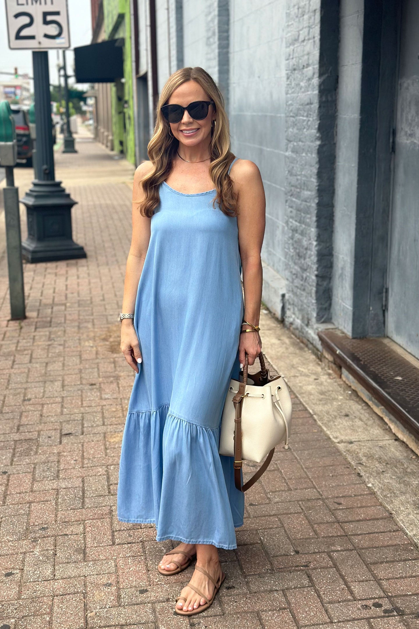 Woman in a blue dress walking on a sidewalk