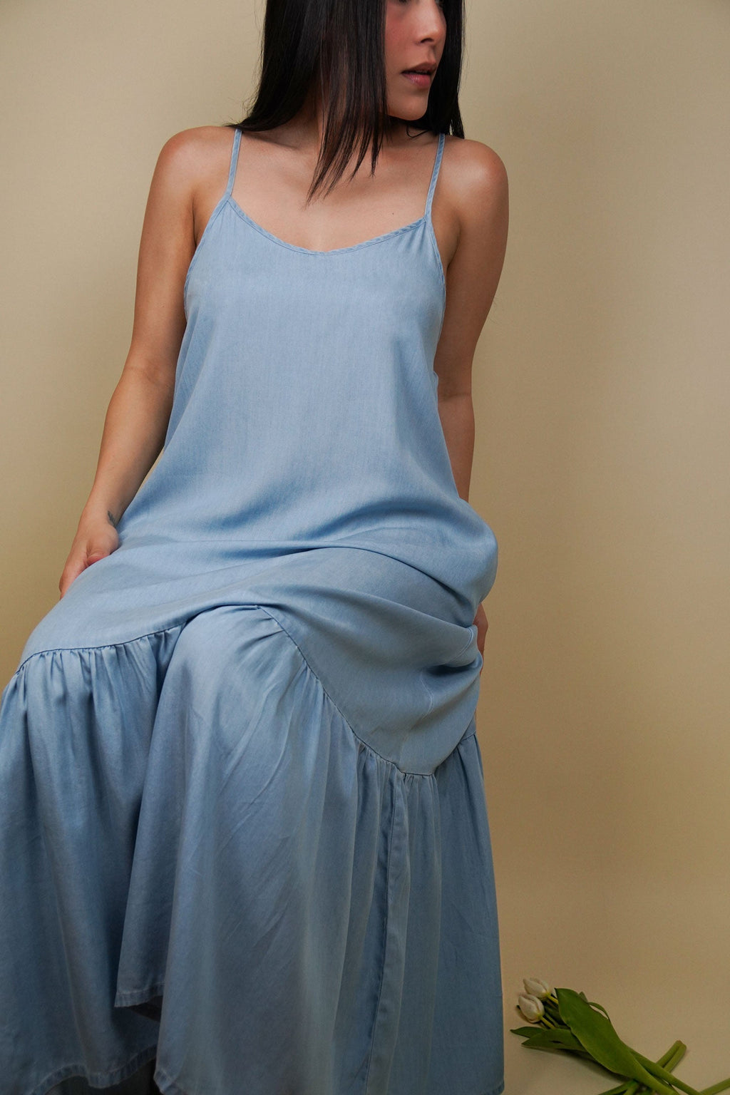Woman wearing a light blue dress against a beige background
